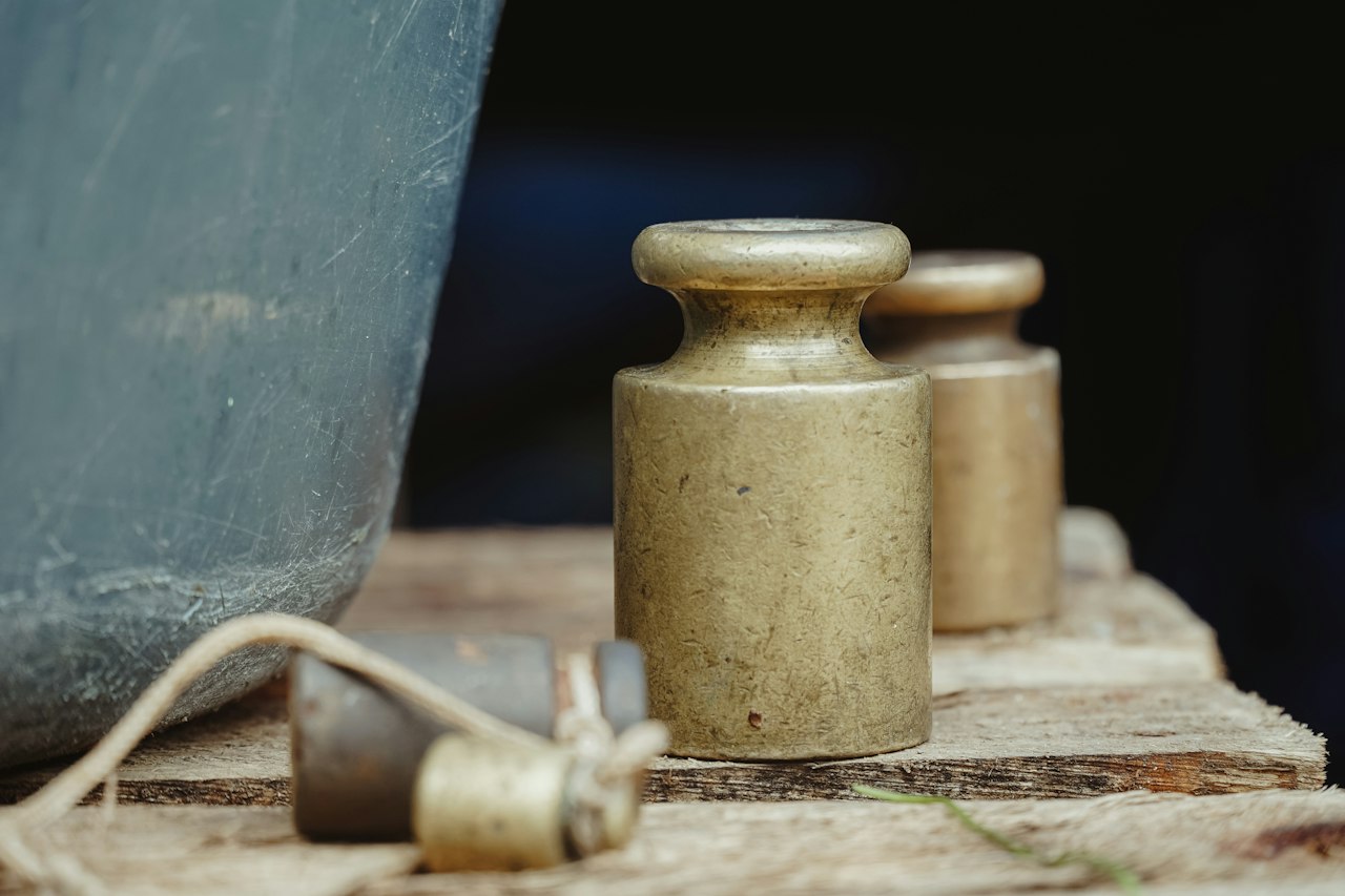 Antique brass weights on a weathered wooden shelf