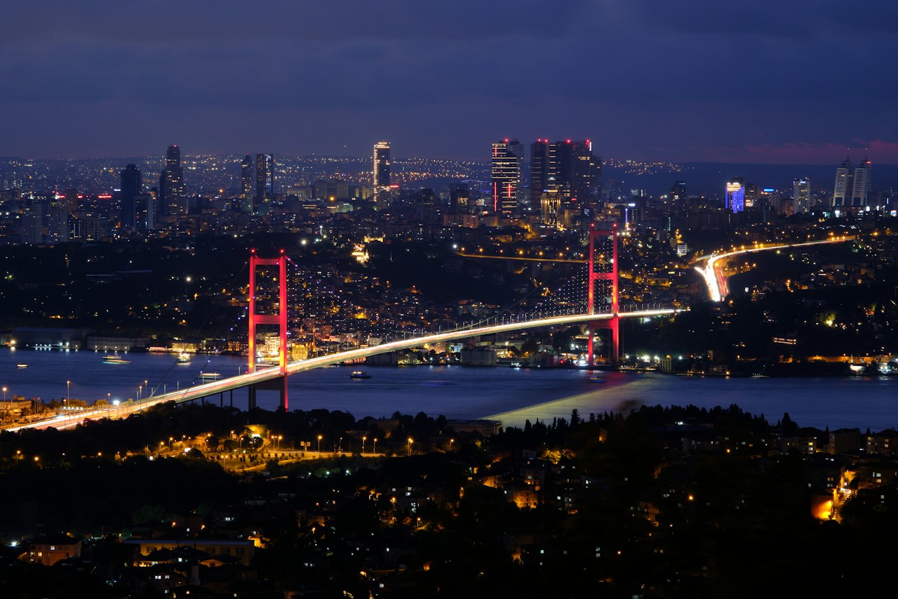 The Bosphorus Bridge and Istanbul's Levent skyline lit at night across the water