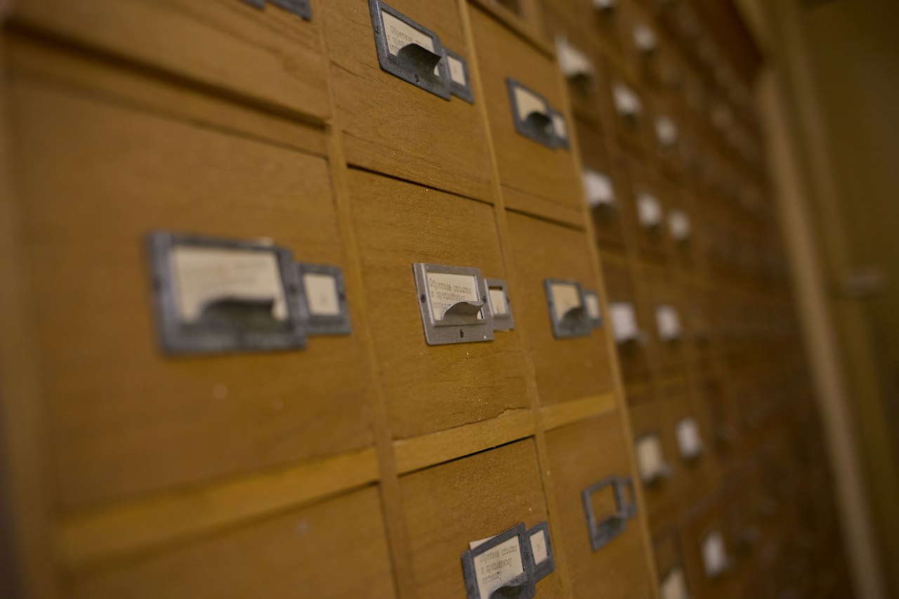 Rows of wooden card-catalogue drawers with brass label holders