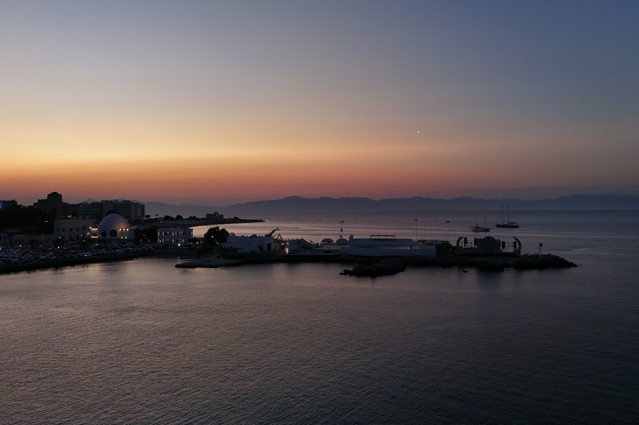 A coastal city and a calm sea at dusk