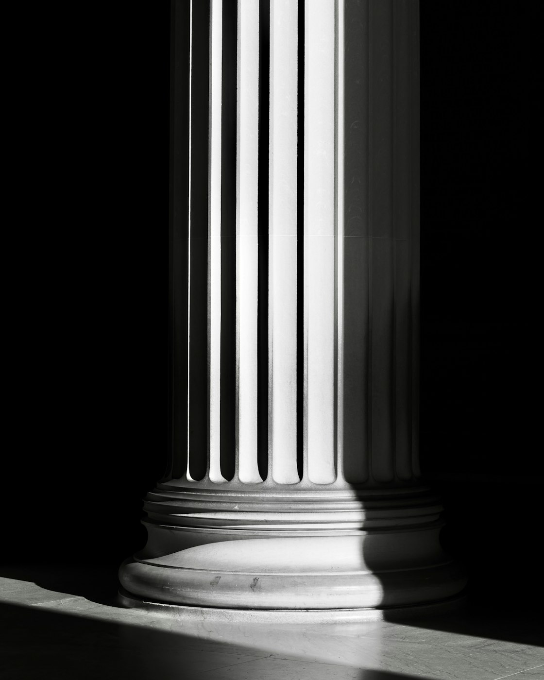 A fluted stone column in a shaft of light