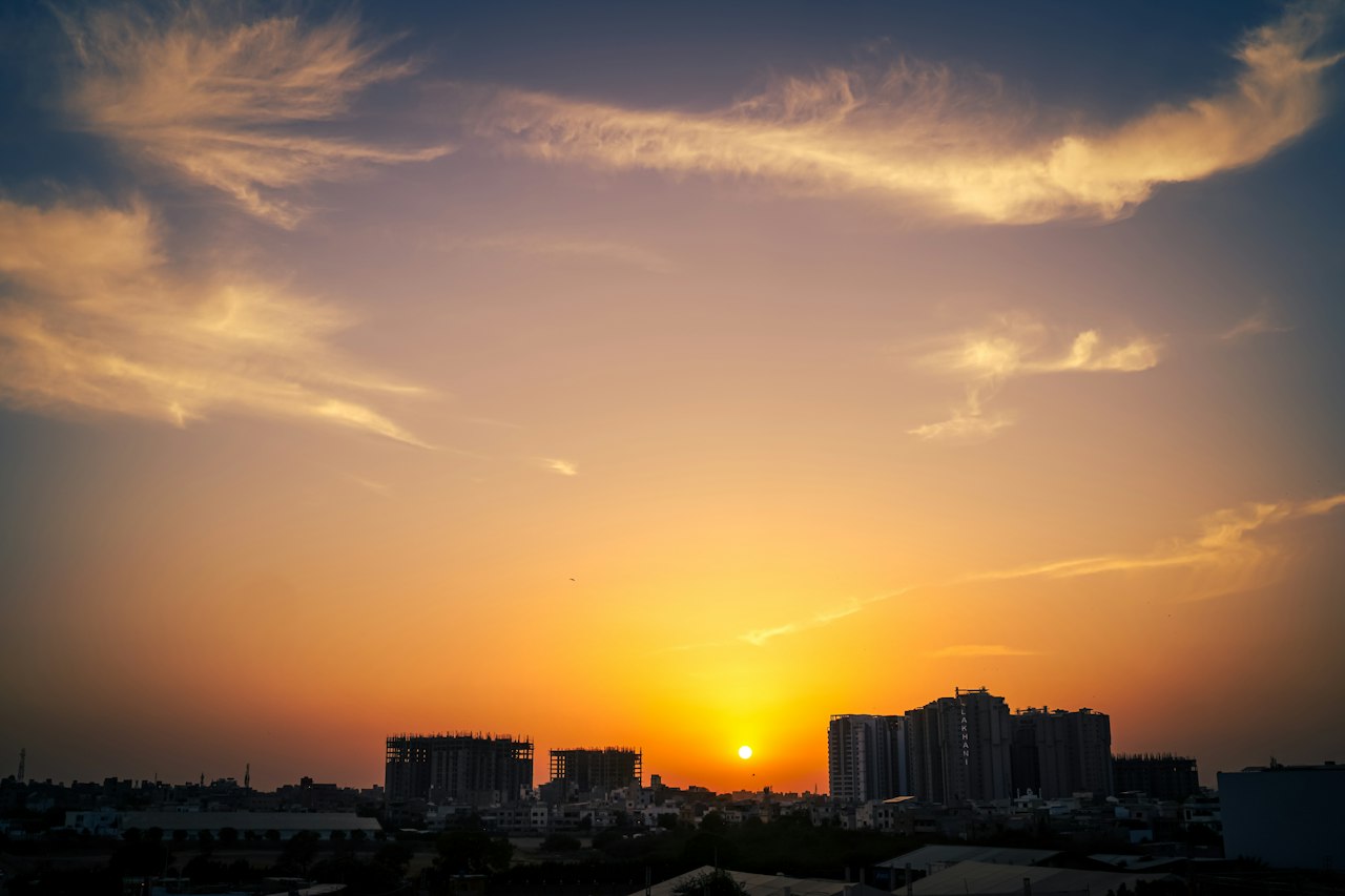 The Karachi skyline silhouetted against a golden sunset sky