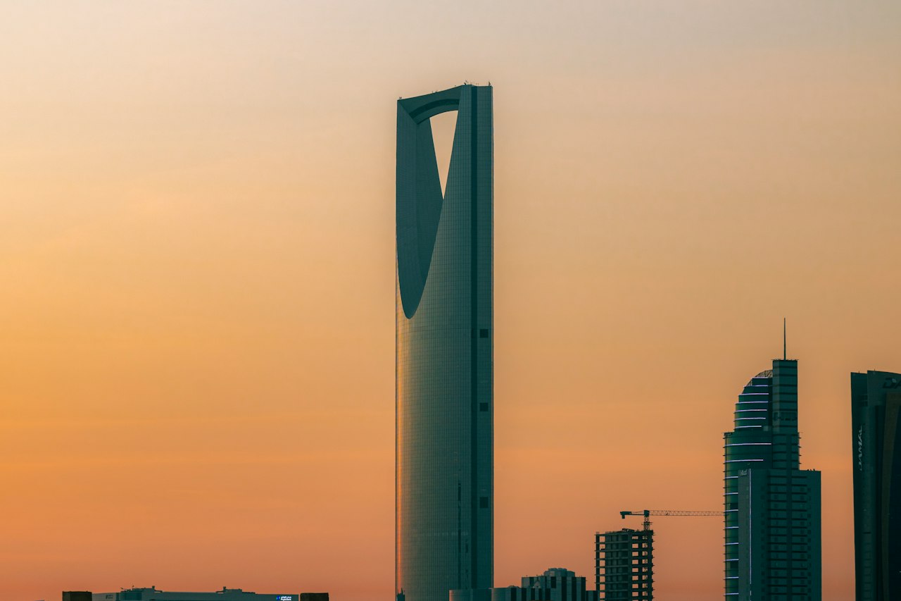 The Kingdom Centre tower silhouetted against a warm dusk sky in Riyadh