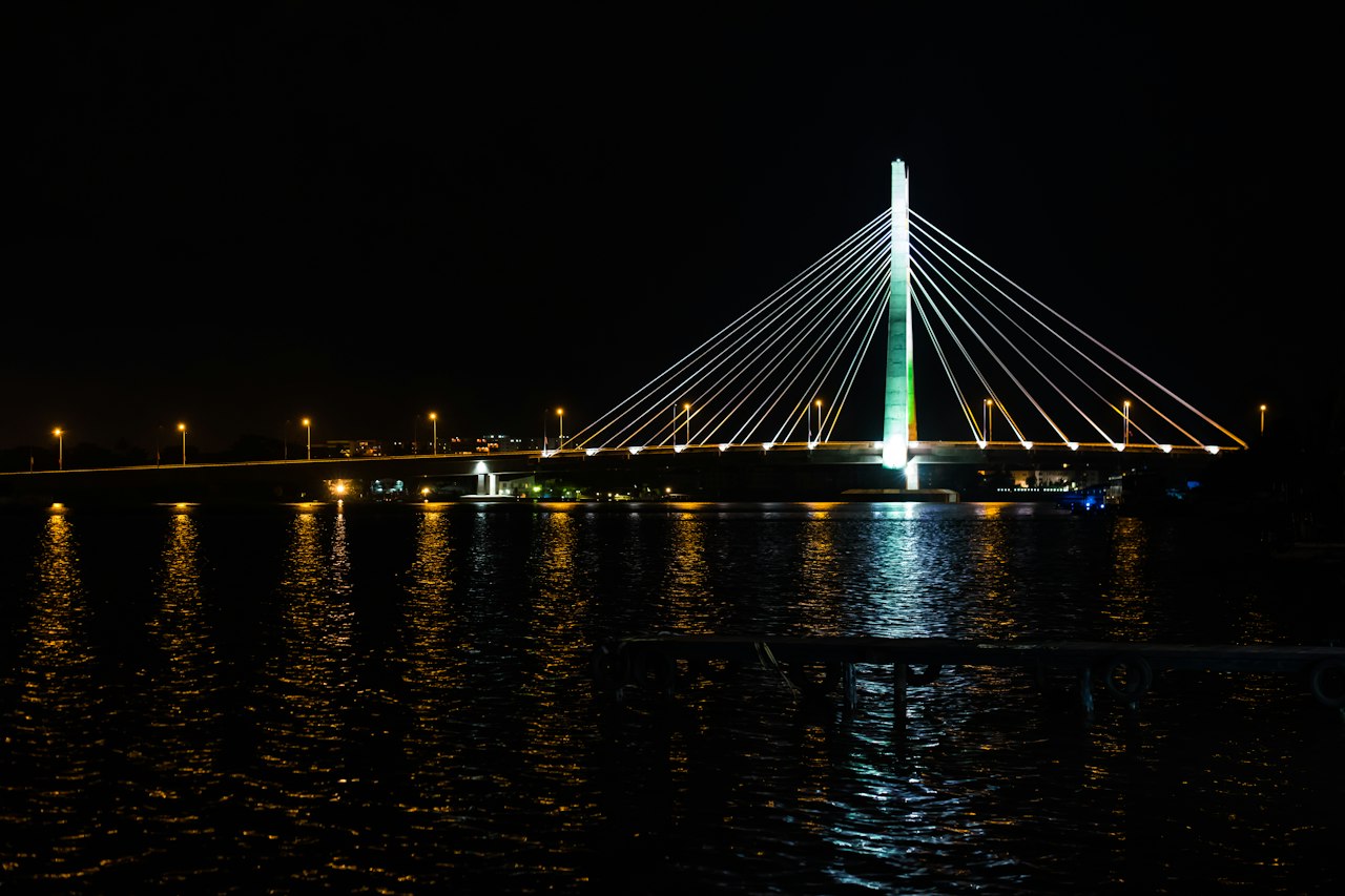 The Lekki-Ikoyi Link Bridge lit at night, its lights reflected in the Lagos lagoon