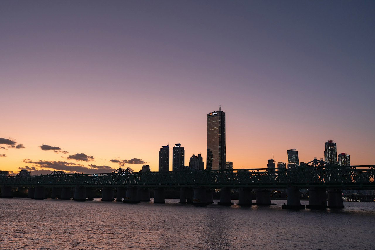 The Seoul skyline and a Han River bridge at dusk