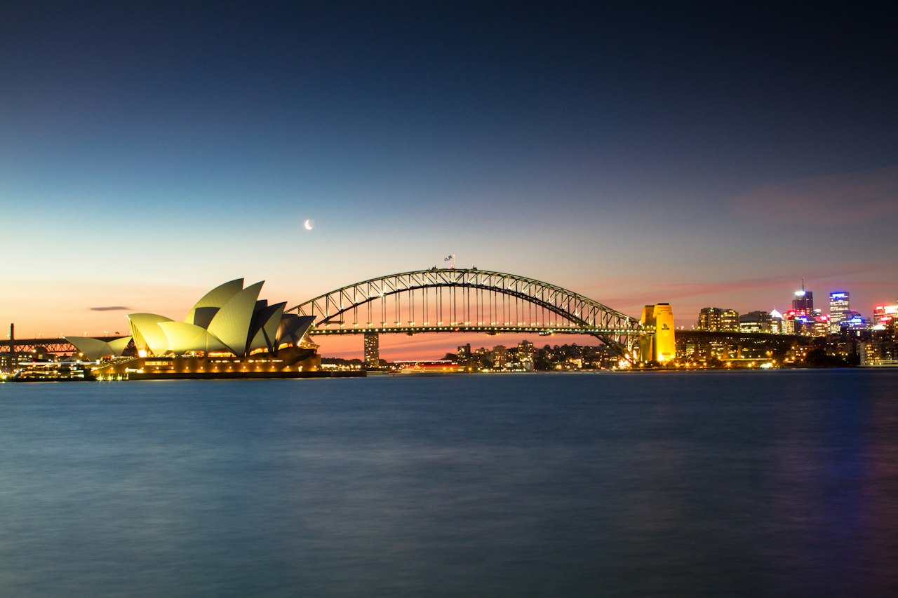 Sydney Opera House and the Harbour Bridge across the harbour at dusk