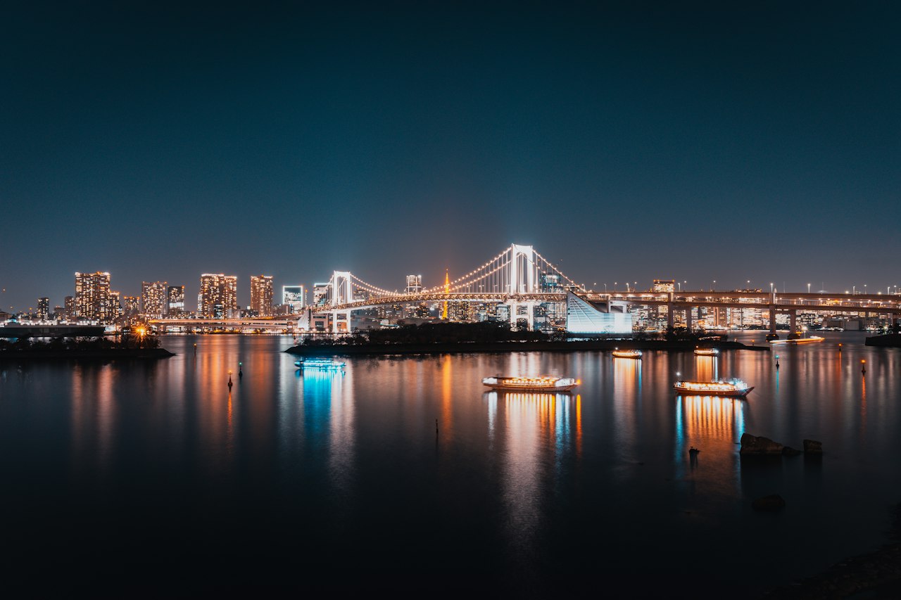 Tokyo Bay and the Rainbow Bridge at night, boat lights reflected in the water